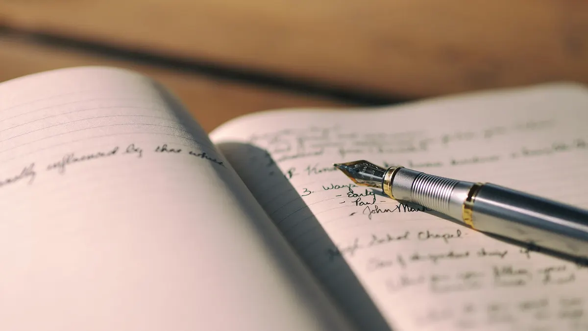 Fountain pen resting on an open handwritten notebook