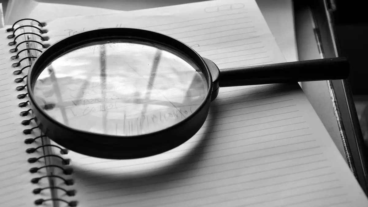 Magnifying glass lying on a lined notebook